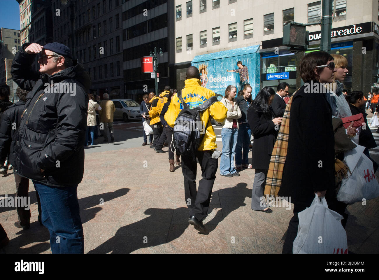 Les touristes et les vendeurs de billets d'autobus d'excursion autour de l'Empire State Building à New York Banque D'Images