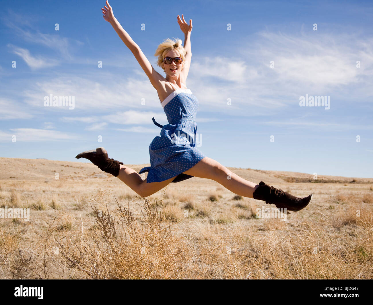 Femme au milieu de nulle part, sautant en l'air. Banque D'Images