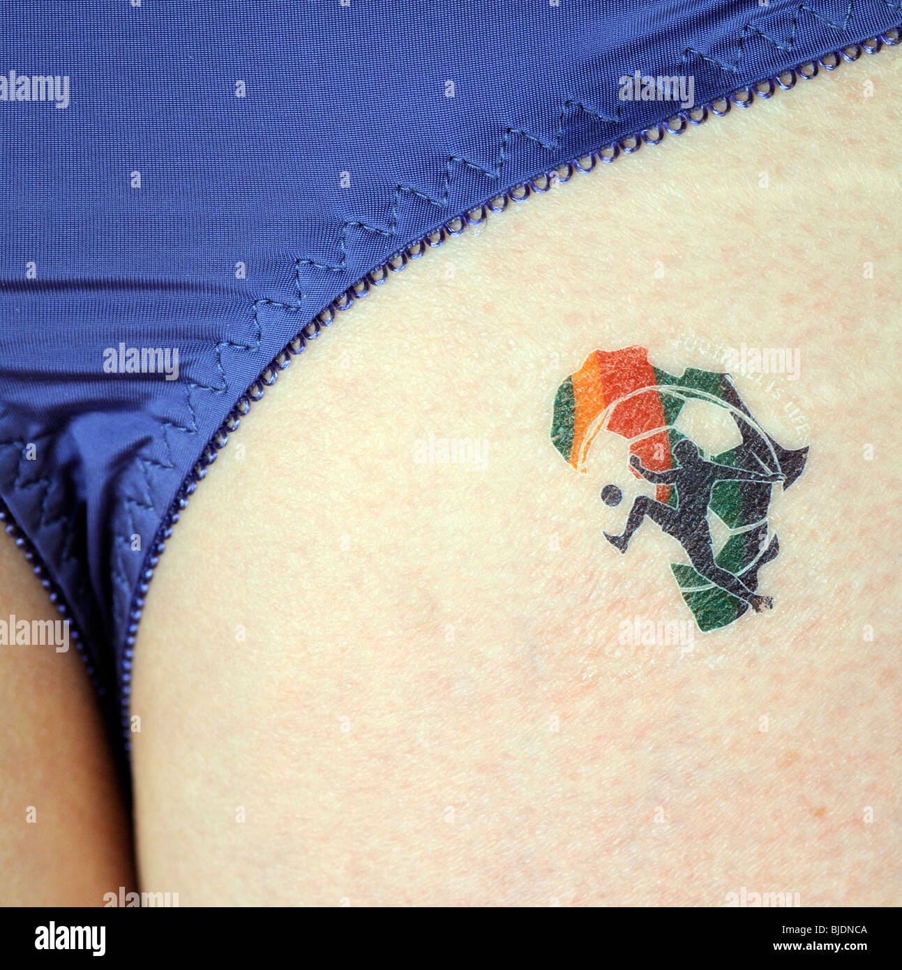Partisan de soccer féminin portant sur sa fesse une 'Le football est la Vie' tattoo de la Coupe du Monde 2010 Afrique du Sud Banque D'Images
