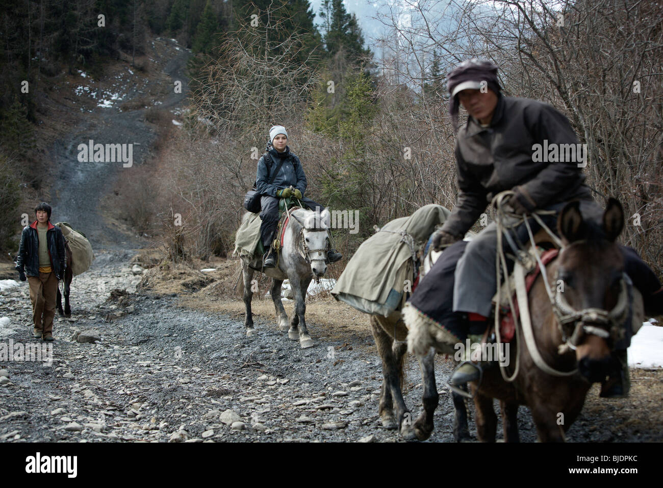 Western girl touristiques sur un cheval trek sur les montagnes près de la ville de Songpan, du Sichuan, Chine. Banque D'Images