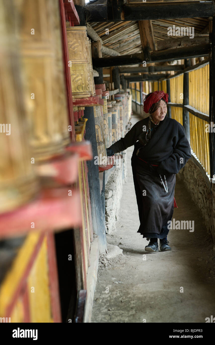 Femme de tourner les roues de prière dans un monastère du bouddhisme tibétain situé près de la ville de Songpan dans Szechuan, Chine. Banque D'Images