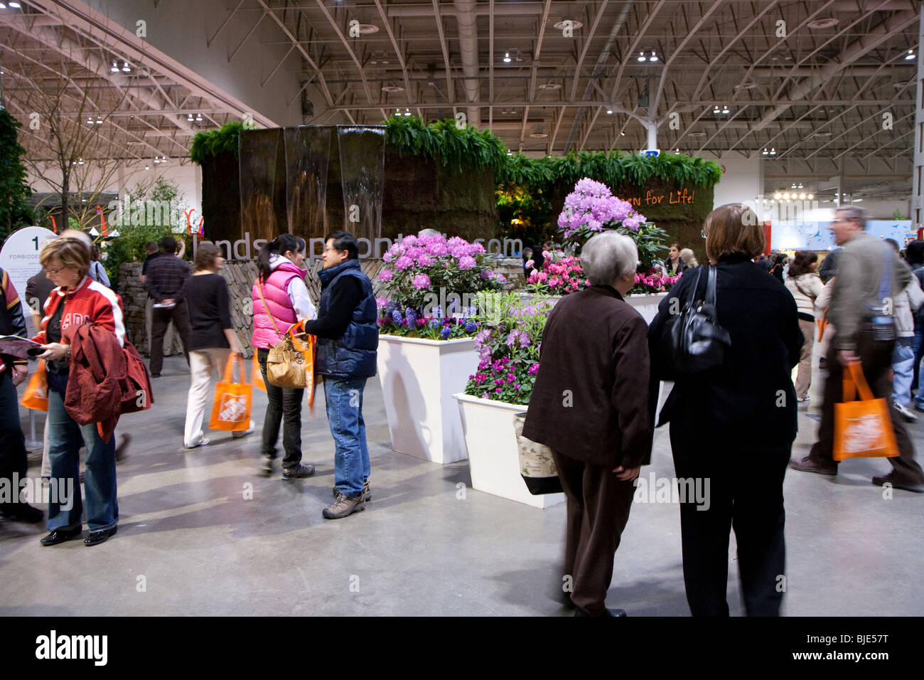Visiteurs transportant des sacs réutilisables orange Home Depot à la fleur et le jardinage Show de Toronto, Canada Banque D'Images