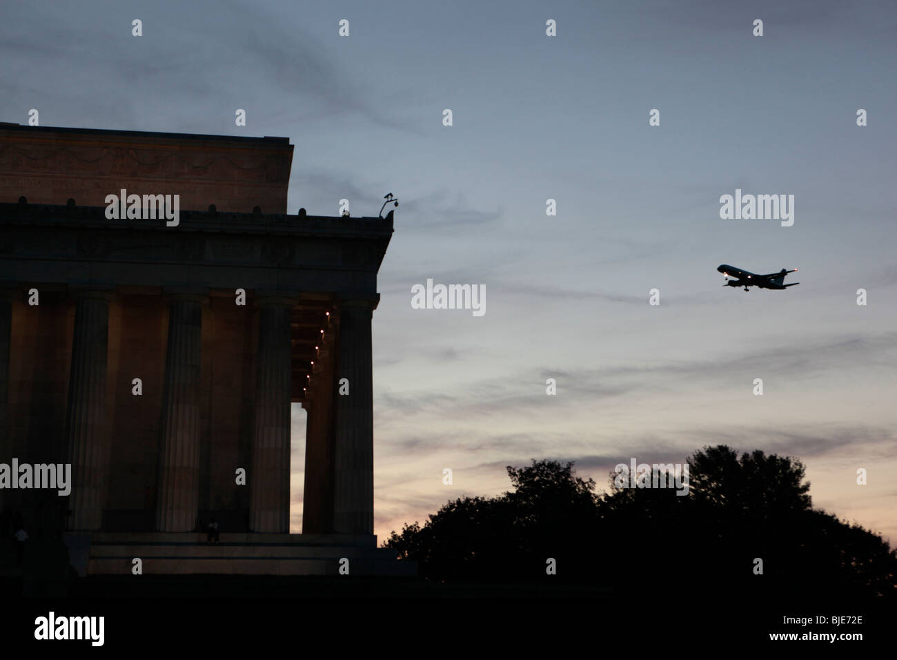 Un jet de passagers défile le Lincoln Memorial à Washington D.C. Voyage destinations tourisme transport compagnies aériennes nuit crépuscule décollage arrivée Banque D'Images
