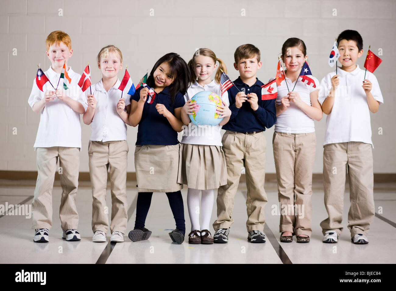 Les enfants de l'école brandissant des drapeaux de différents pays Banque D'Images