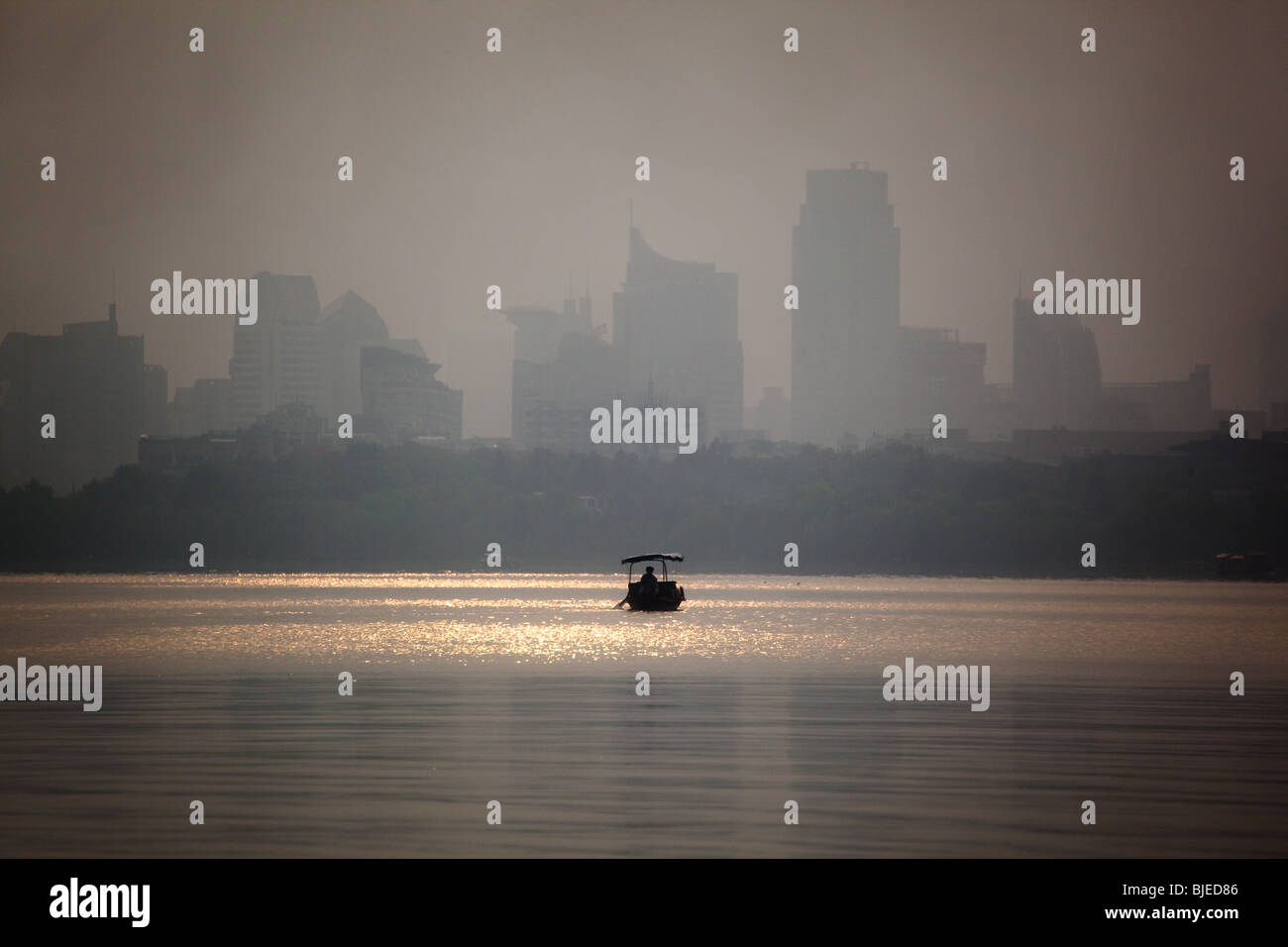 Bateau de pêche dans la brume matinale sur Xi Hu, Lac de l'Ouest, à Hangzhou, Chine Banque D'Images