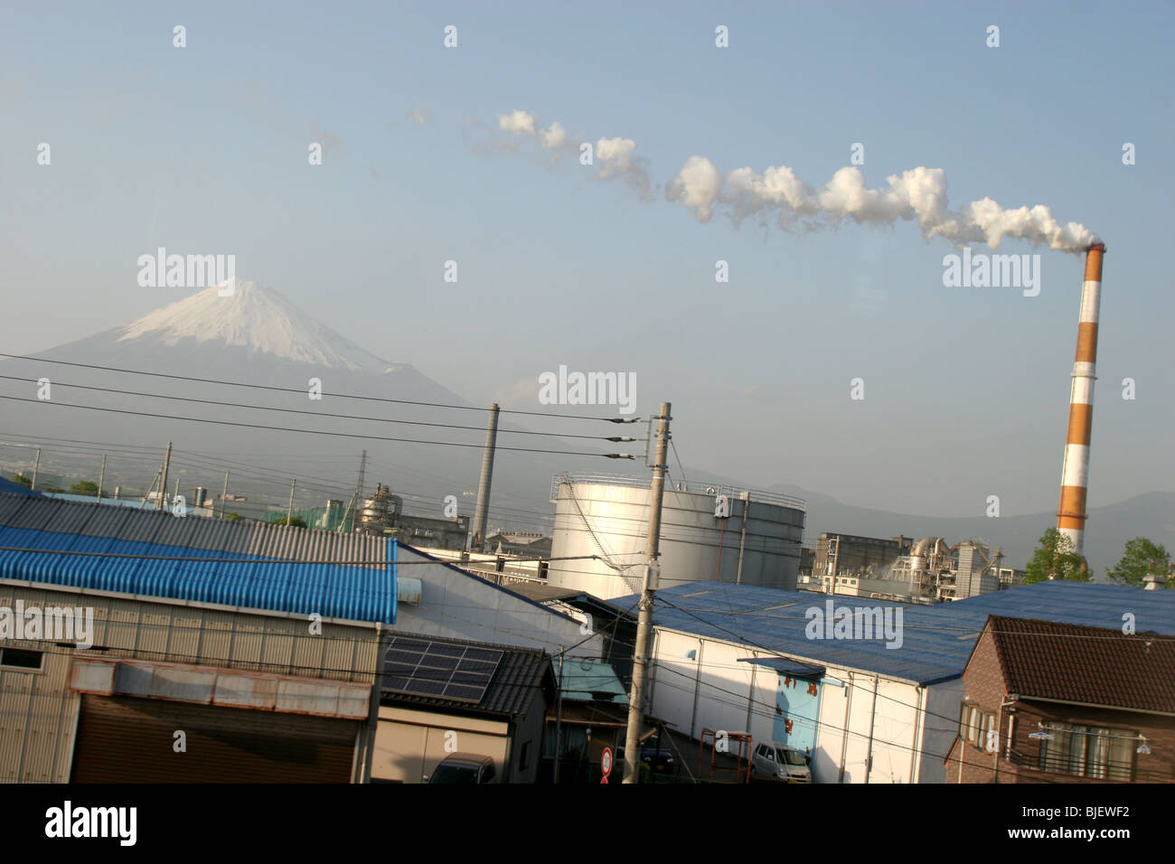 Le Mont Fuji, vu de la fenêtre d'un Shinkansen, le train qui passe, avec un complexe industriel en premier plan, le Japon. Banque D'Images