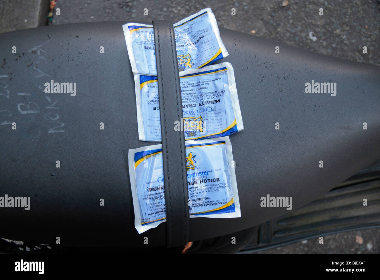 Les contraventions de stationnement fixé au siège d'une moto garée à Londres, au Royaume-Uni. L'année 2009. Banque D'Images