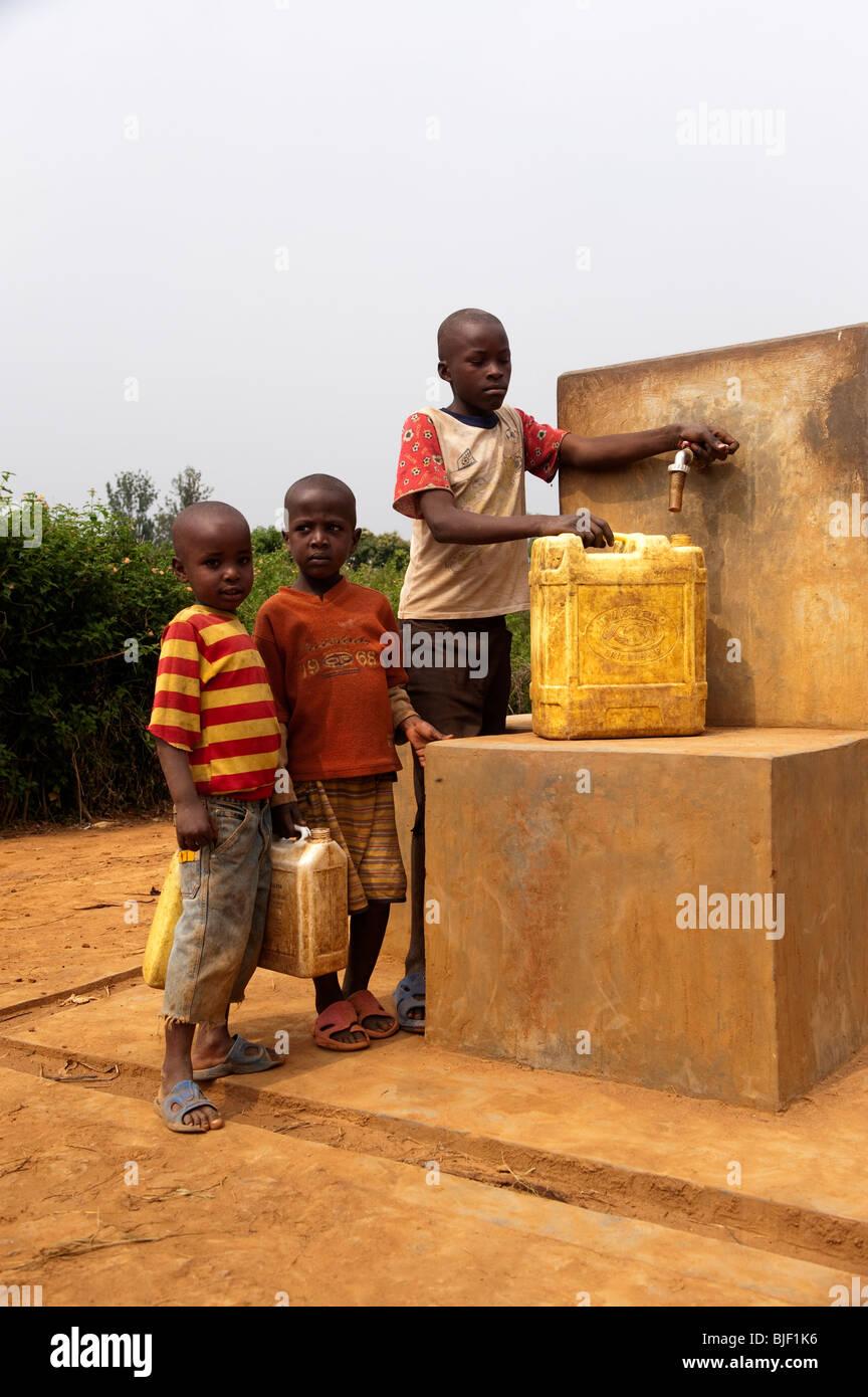 Les enfants essayant d'obtenir de l'eau d'un puits sec. Le Rwanda Banque D'Images