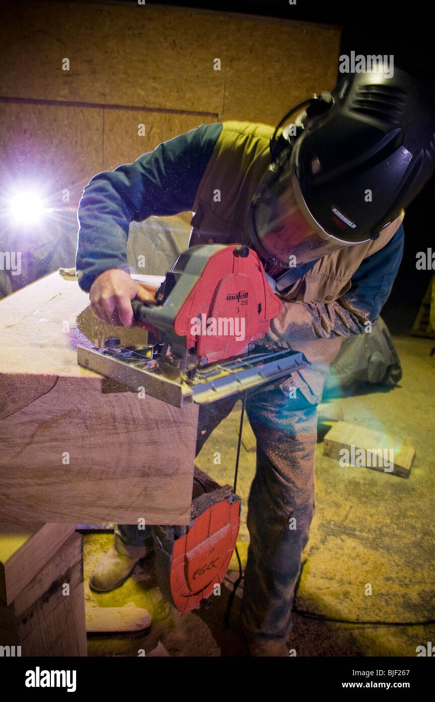 L'homme à l'aide d'une scie à ruban sophistiqués de couper à travers bois très épais Banque D'Images