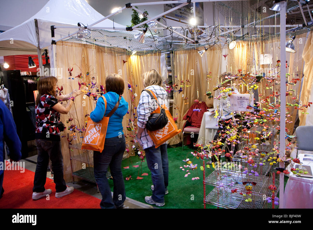 L'embarquement d'un vendeur d'un produit à deux femmes sacs shoppers avec Home Depot à un show de jardinage Banque D'Images
