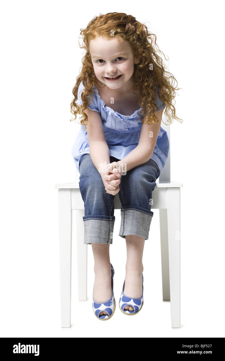 Fille assise sur une chaise Banque D'Images