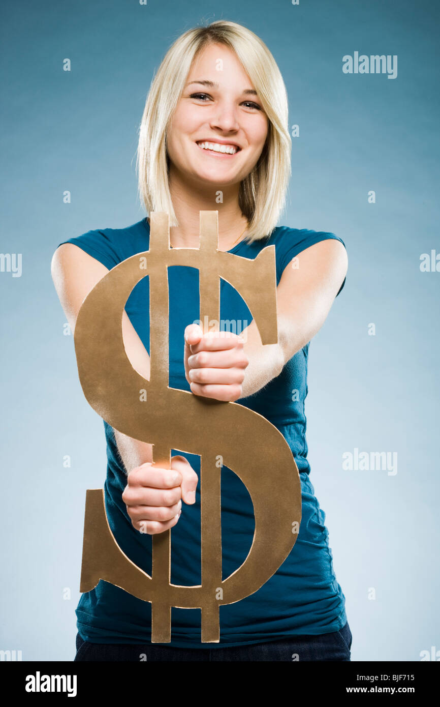 Woman holding up un symbole dollar Banque D'Images