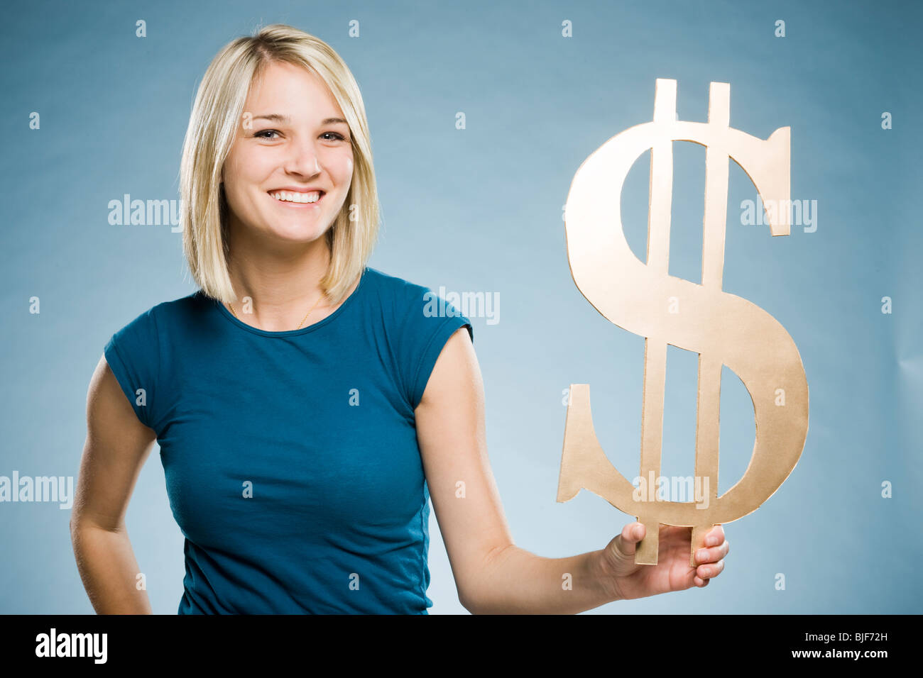 Woman holding up un symbole dollar Banque D'Images