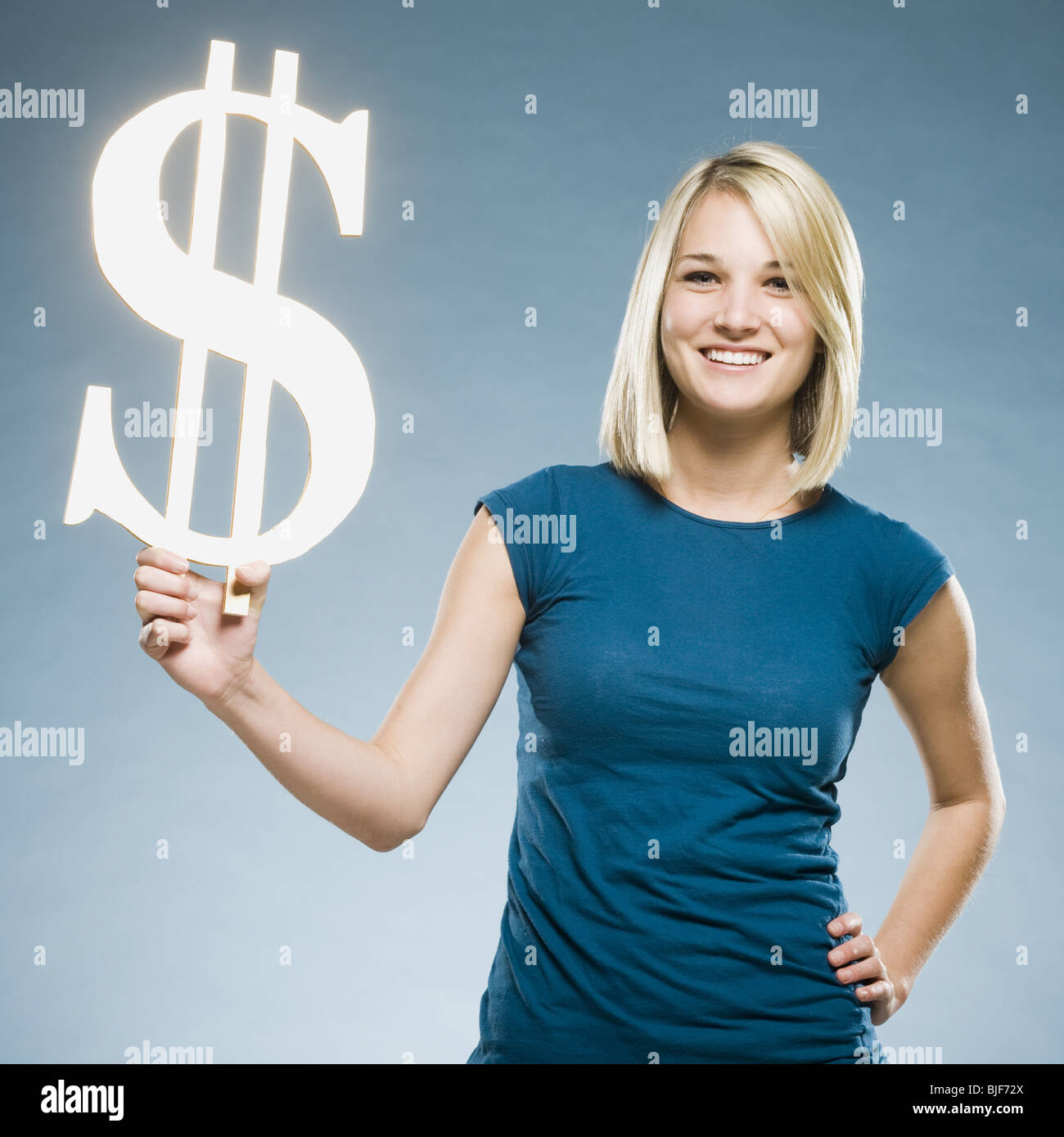 Woman holding up un symbole dollar Banque D'Images