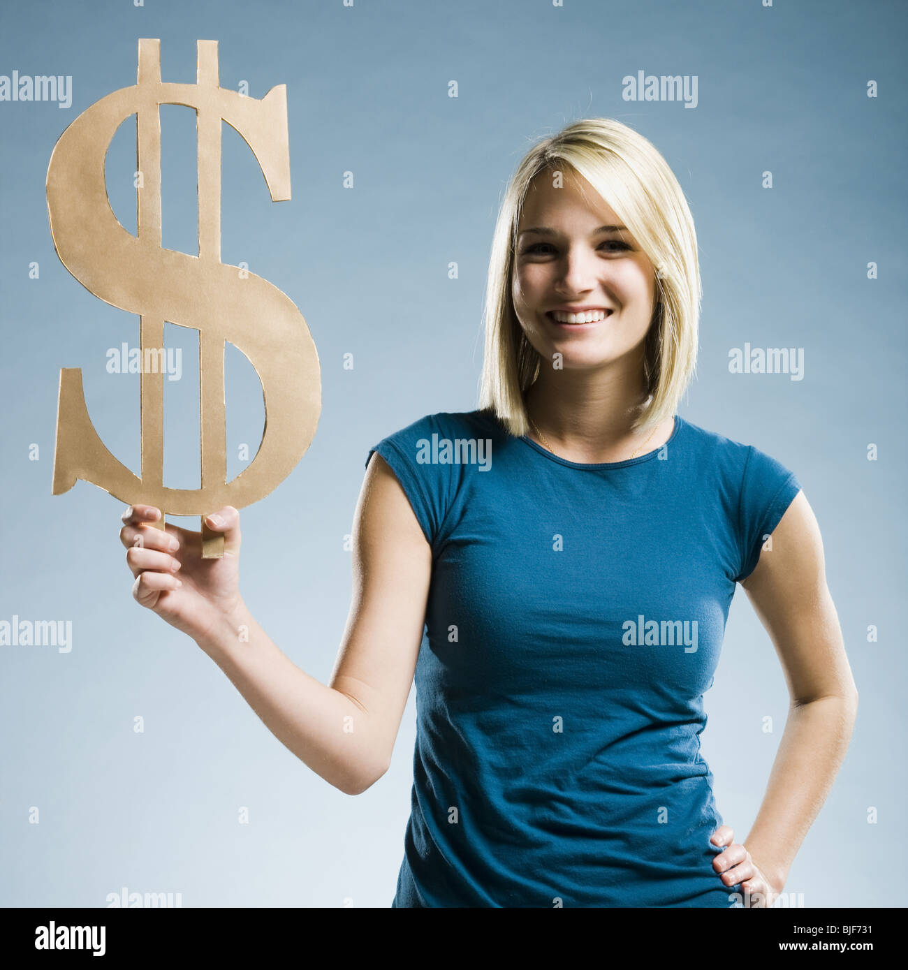 Woman holding up un symbole dollar Banque D'Images