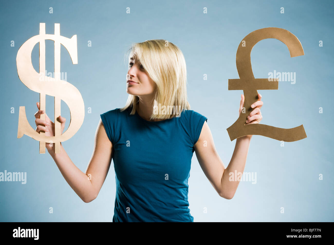 Woman holding up symboles monétaires Banque D'Images