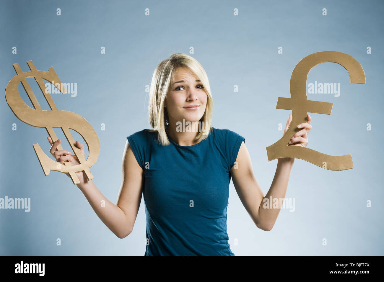 Woman holding up symboles monétaires Banque D'Images