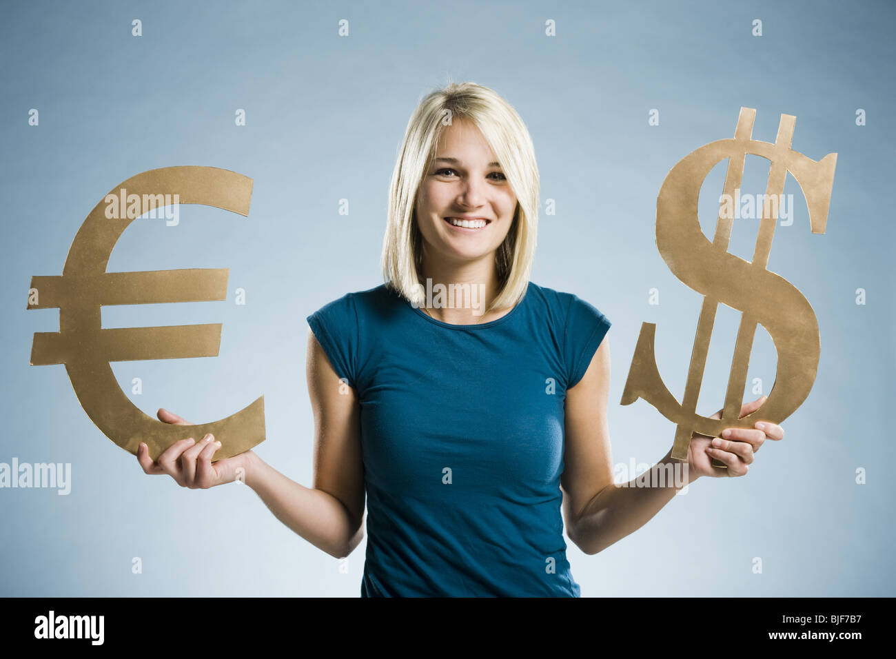 Woman holding up symboles monétaires Banque D'Images