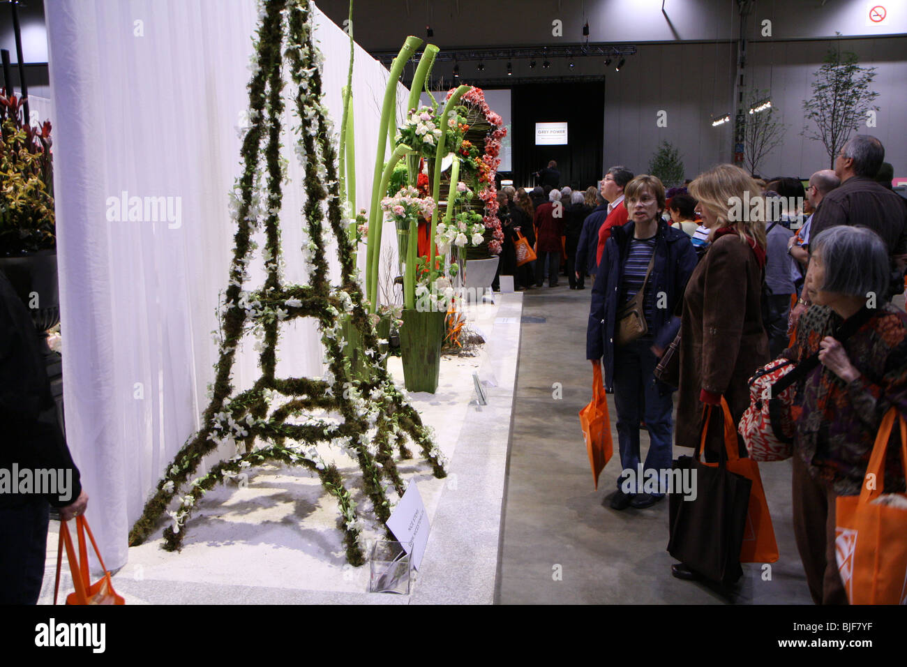 Visiteurs visiteurs regardant montres des arrangements de fleurs taille Banque D'Images