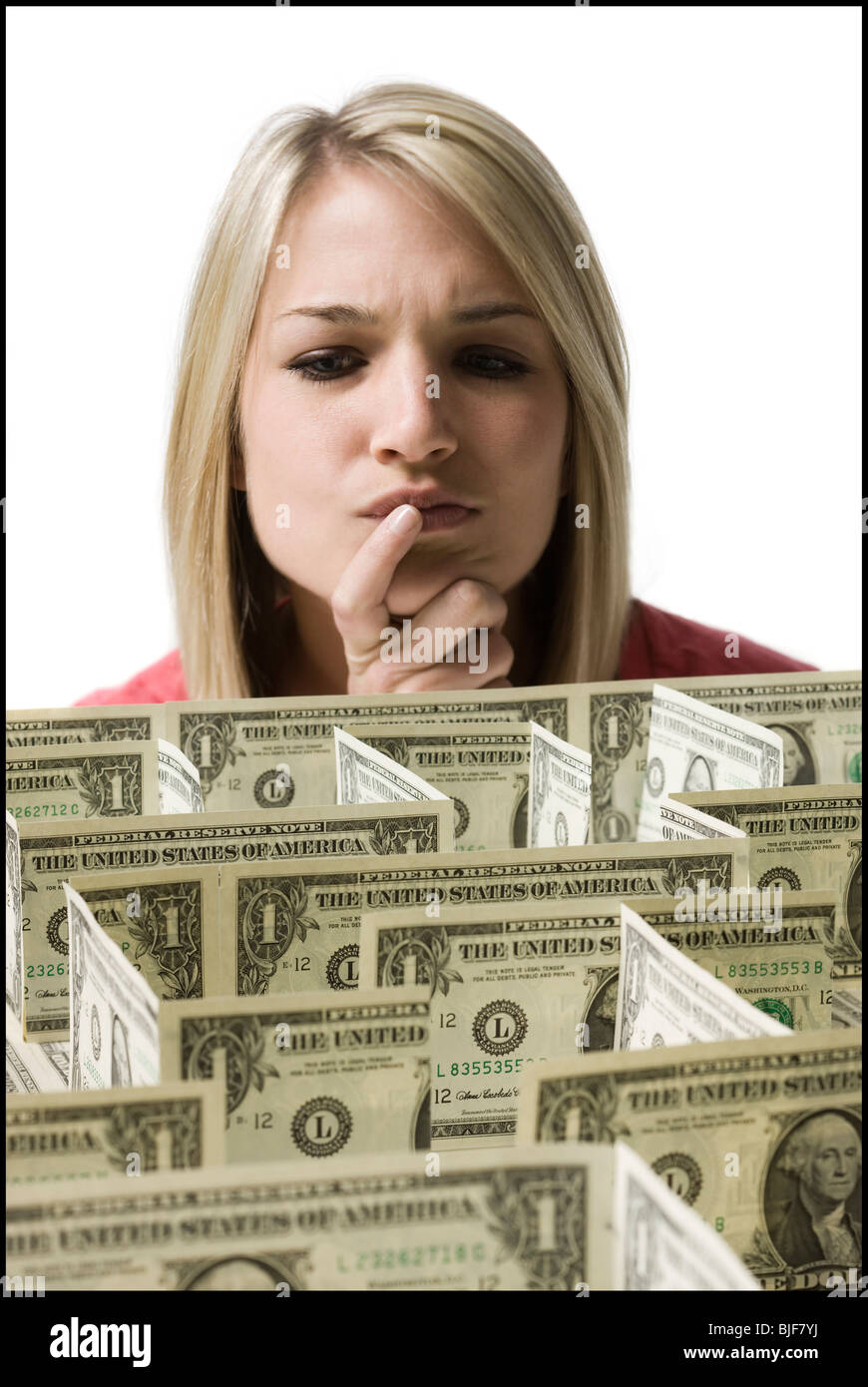 Femme regardant un labyrinthe fait de dollars Banque D'Images