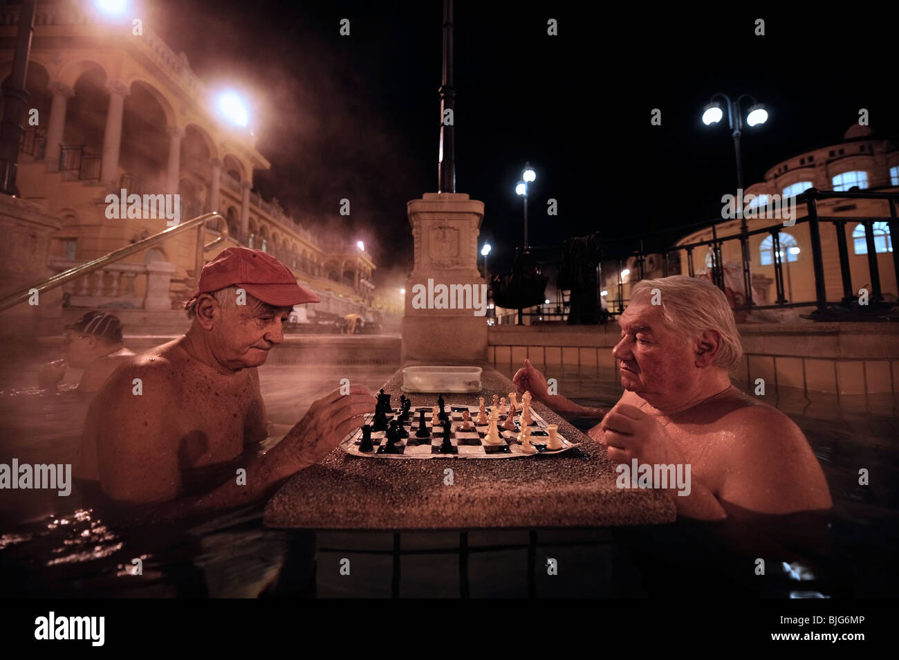 Les hommes jouant aux échecs dans les bains de Szechenyi sur une froide nuit d'hiver à Budapest, Hongrie Banque D'Images
