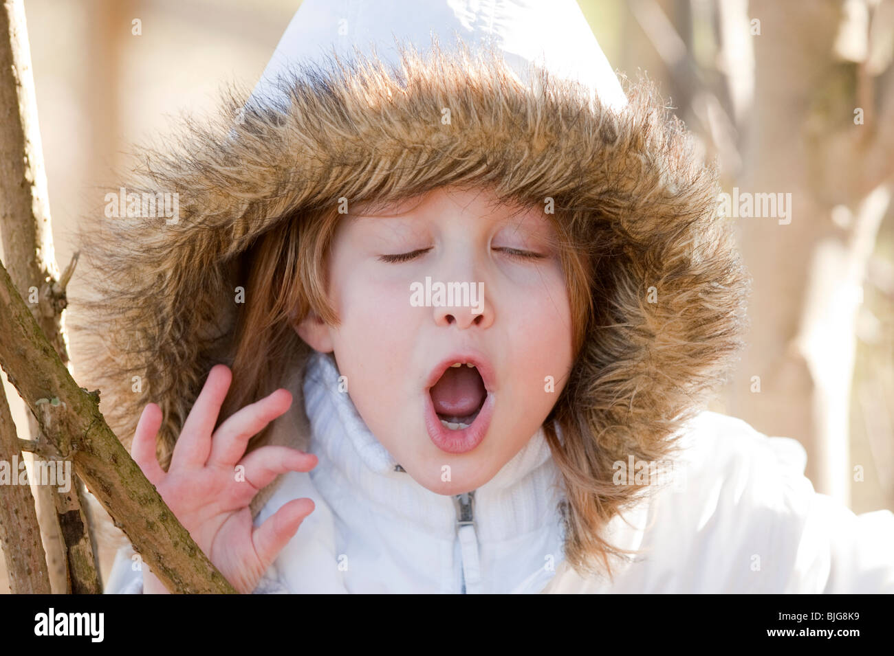 7 ans, fille en manteau d'hiver avec capuche de bâiller. Modèle entièrement libéré Banque D'Images