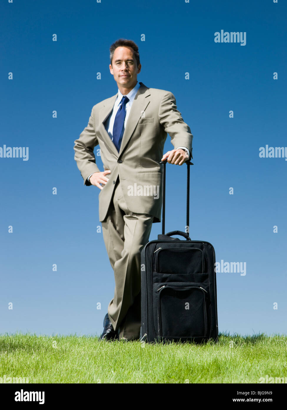 Businessman with a rolling suitcase Banque D'Images
