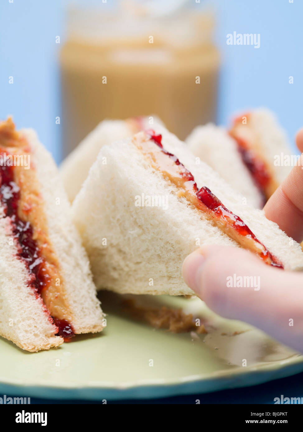 Hand Reaching for peanut butter and jelly sandwich - Banque D'Images