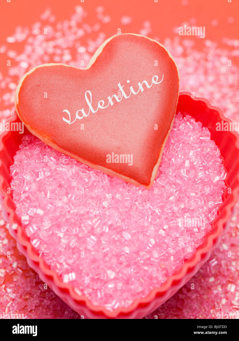 Coeur de vanille avec du rouge cerise sur le sucre rose - Banque D'Images