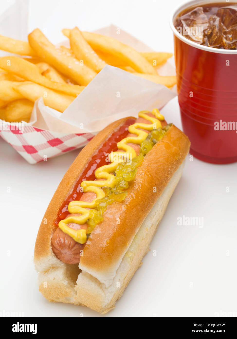 Un hot-dog, une portion de frites et une tasse en plastique de cola - Banque D'Images