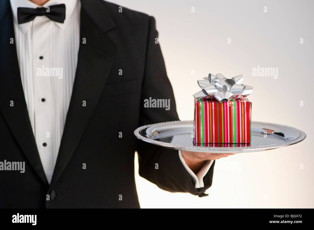Butler holding gift Banque D'Images