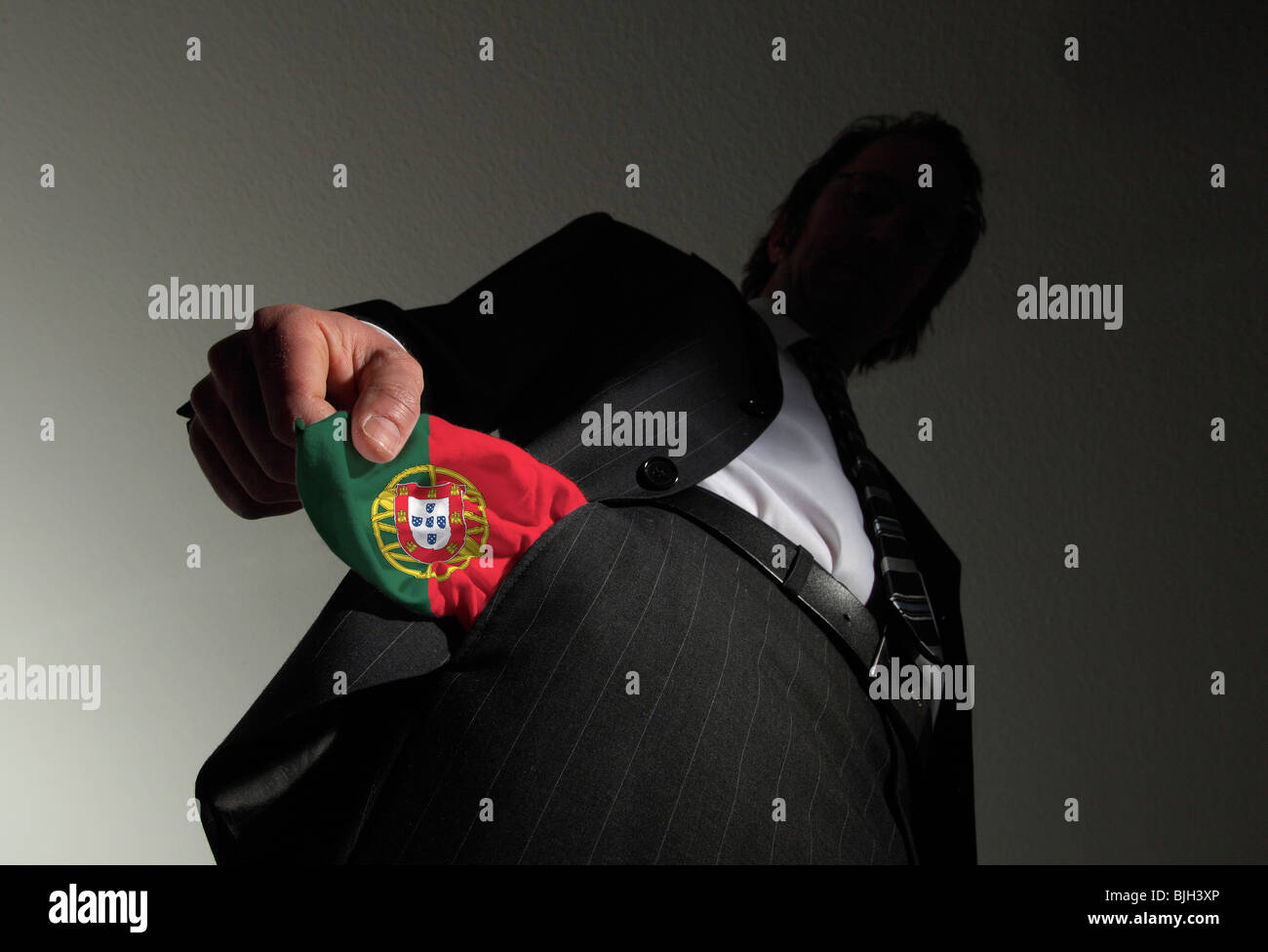 Homme en costume avec poches vides dans les couleurs nationales du Portugal. Symbole : Le Portugal est en faillite Banque D'Images