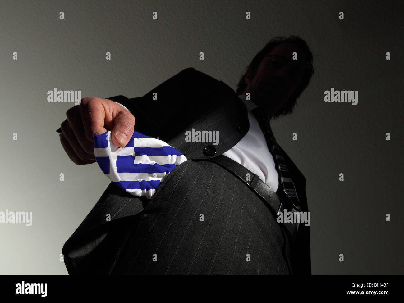 Homme en costume avec poches vides dans les couleurs nationales de la Grèce. Symbole : la Grèce est en faillite Banque D'Images