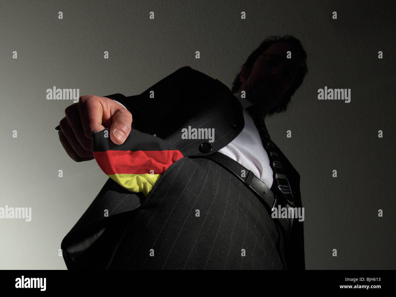 Homme en costume avec poches vides dans les couleurs nationales de l'Allemagne. Symbole : L'Allemagne est en faillite Banque D'Images