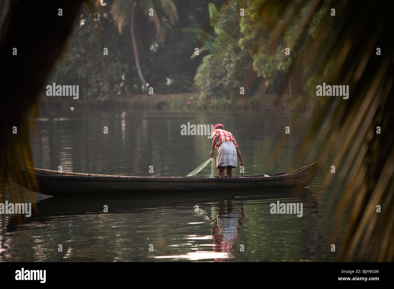 L'Inde, le Kerala, Alappuzha, Chennamkary, backwaters, pêcheur de pêche petite pirogue en bois Banque D'Images