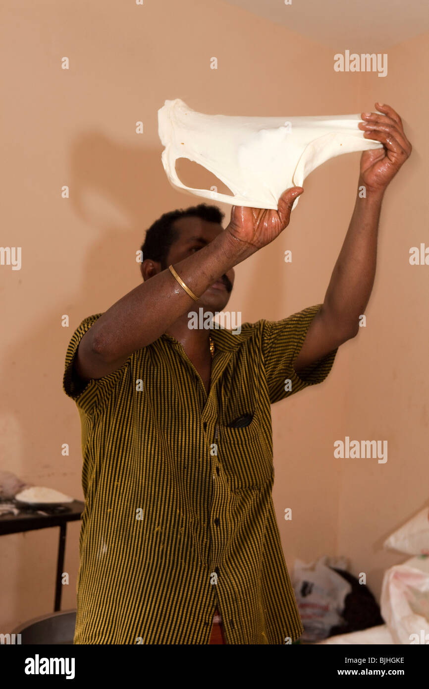 L'Inde, le Kerala, Kodikuthu Kanjiramattom festival musulman, l'homme de tourner la pâte pour la rendre Paratha Placez fine Banque D'Images