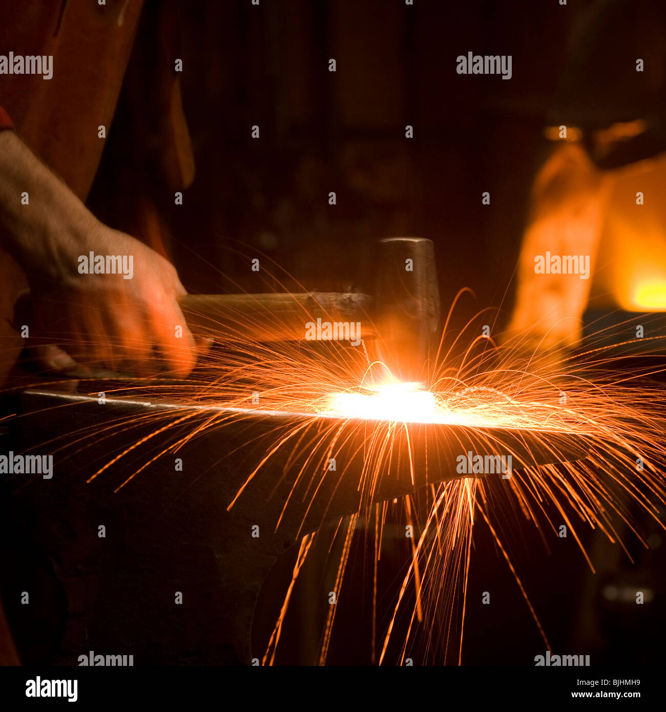Marteau frappant un morceau de métal chaud sur une enclume Banque D'Images