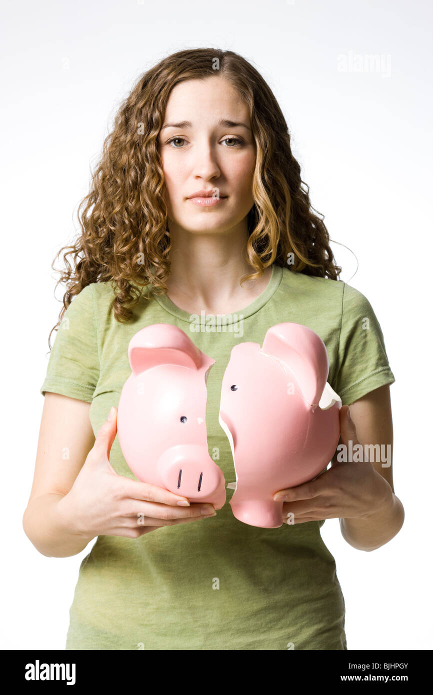 Woman holding a broken piggy bank Banque D'Images