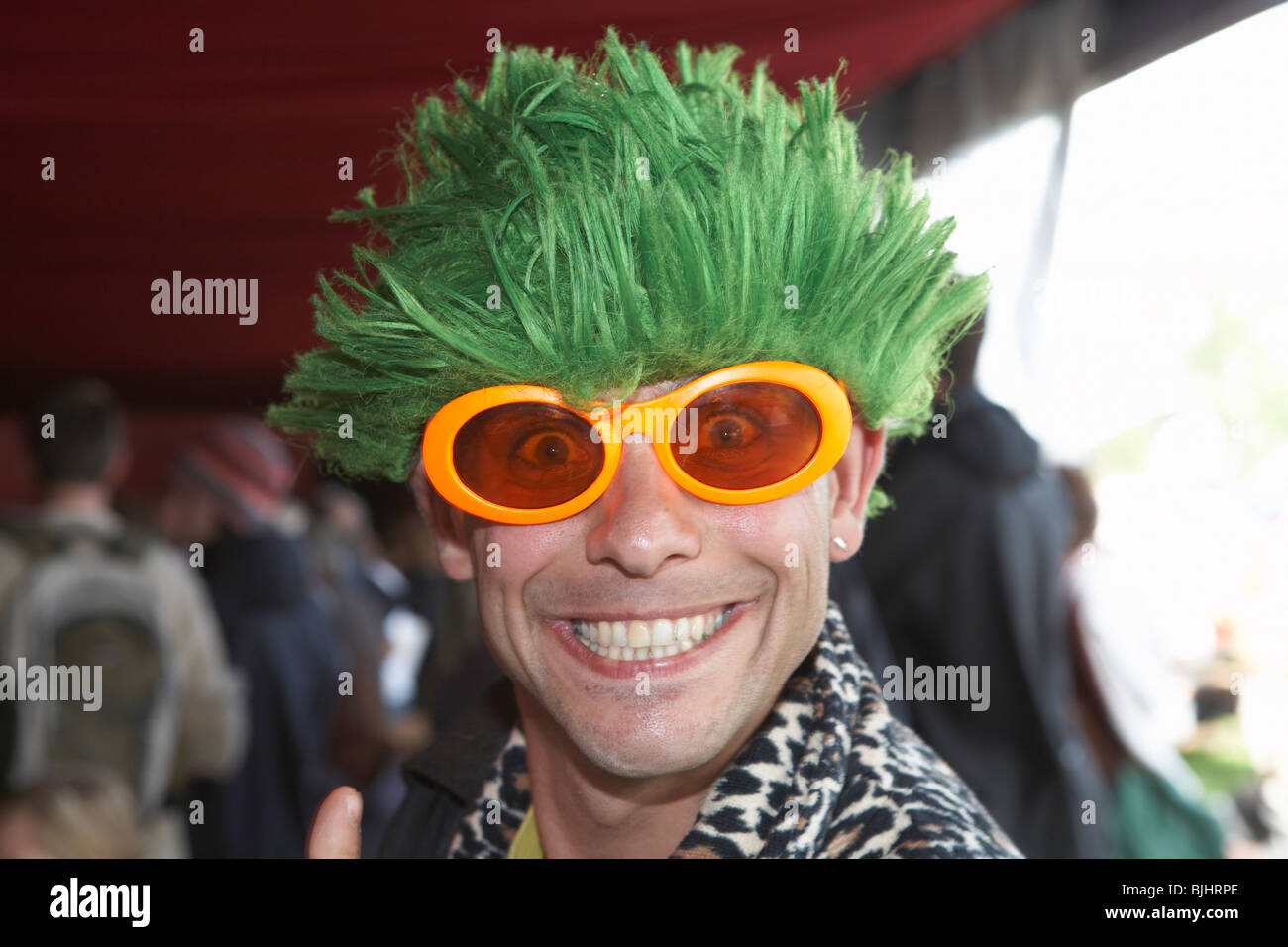 Homme avec cheveux greeen et de nuances dans l'un des nombreux bars à Glastonbury Festival 2007 Banque D'Images