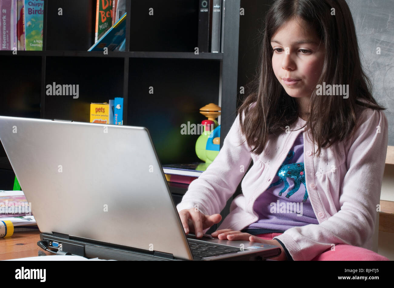 Lycéenne sur un ordinateur portable à la maison Banque D'Images