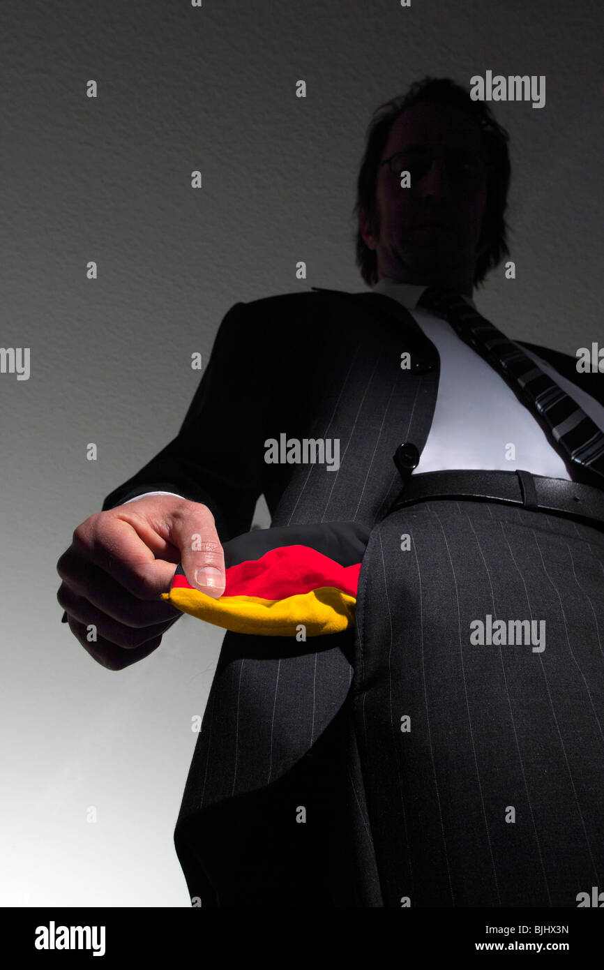 Homme en costume avec poches vides dans les couleurs nationales de l'Allemagne. Symbole : L'Allemagne est en faillite Banque D'Images