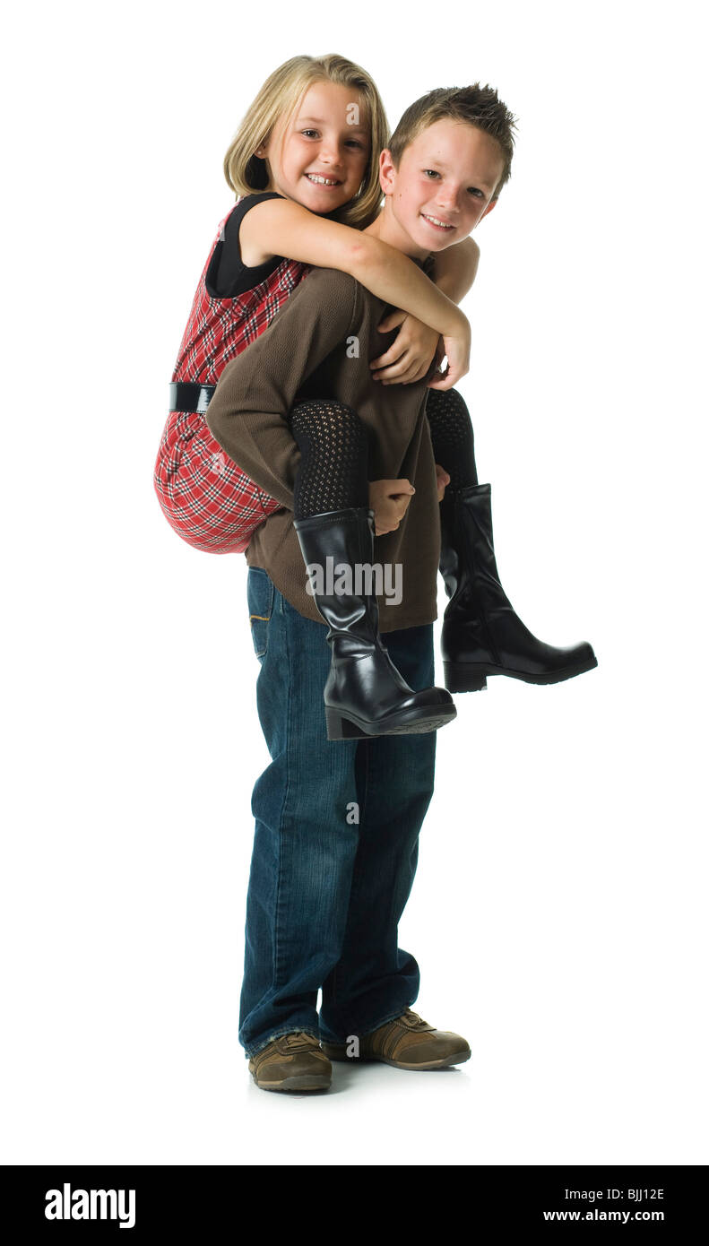 Boy giving piggy back ride girl smiling Banque D'Images