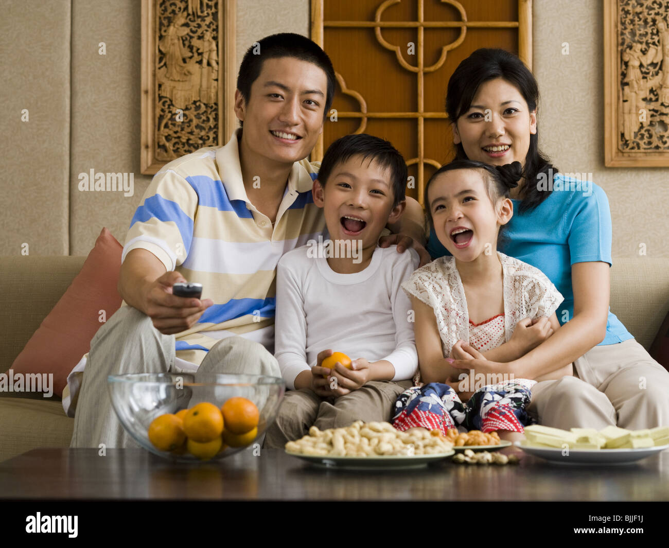 Famille le canapé à regarder la télévision Banque D'Images