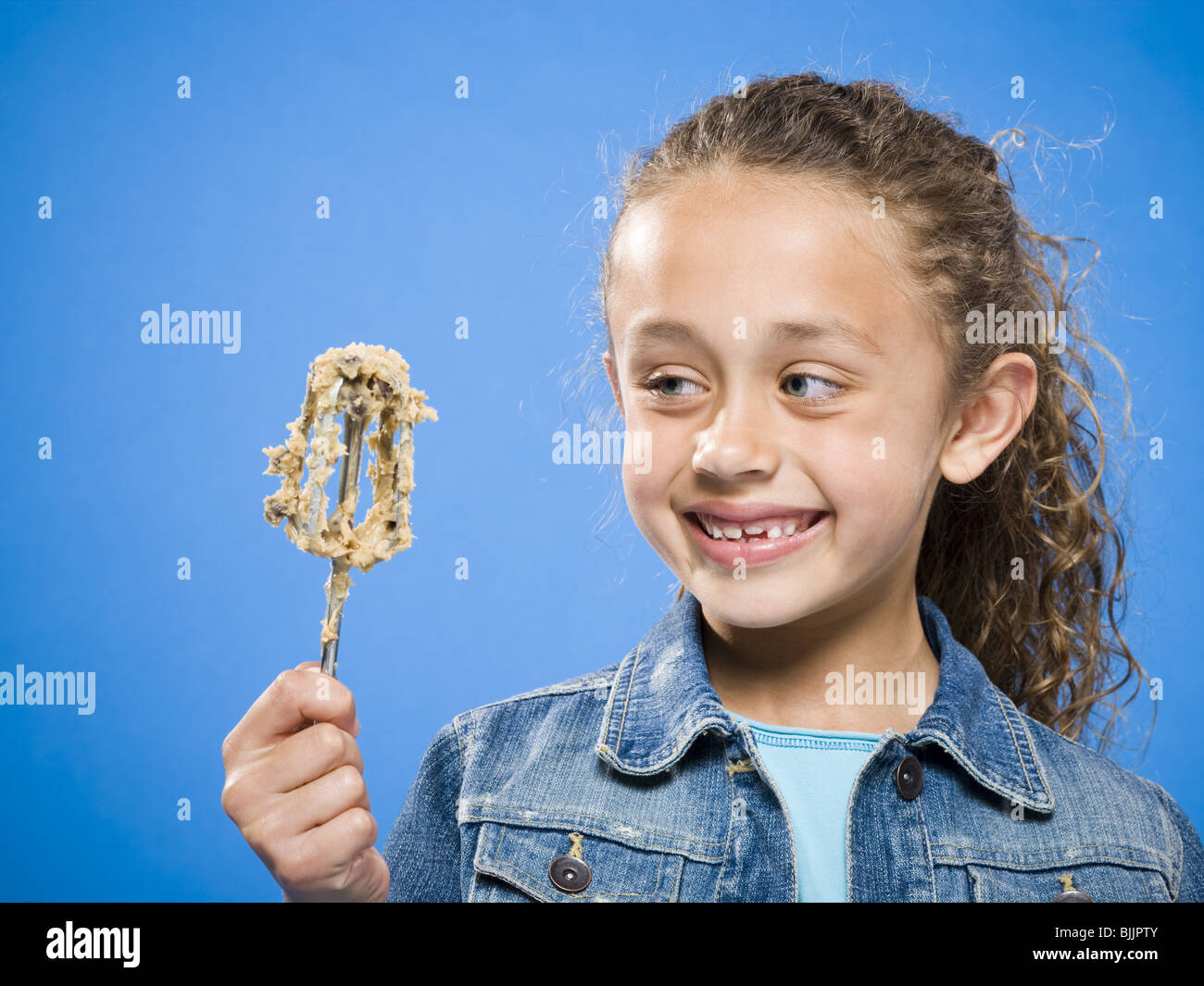 Profil de girl licking batter off tire-paille Banque D'Images