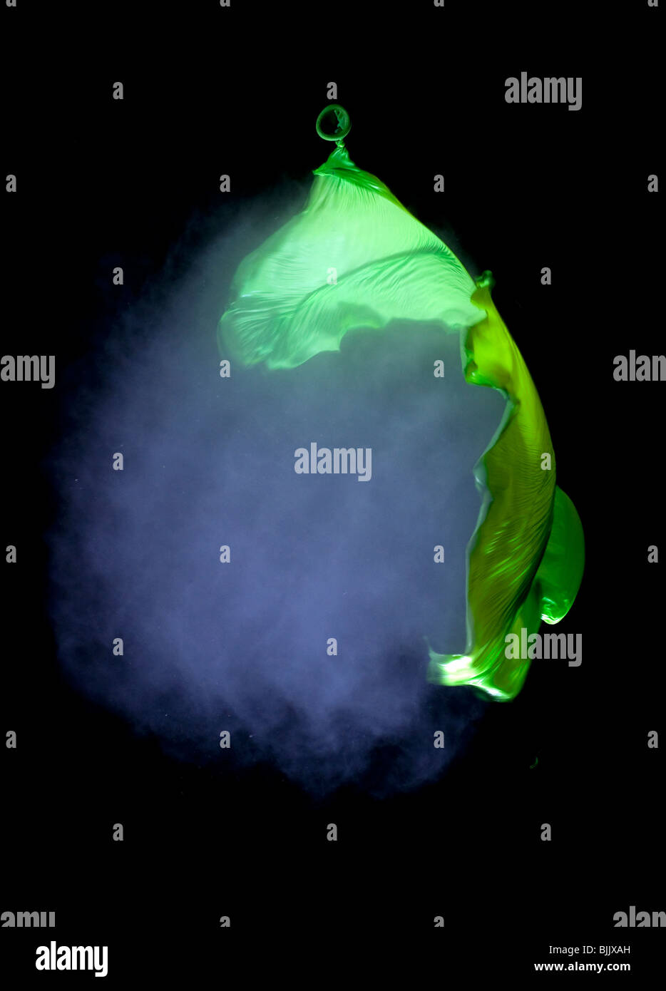 Un ballon vert rempli de fumée lors de l'éclatement tourné avec une carabine à air. Visible de l'onde sonore Banque D'Images
