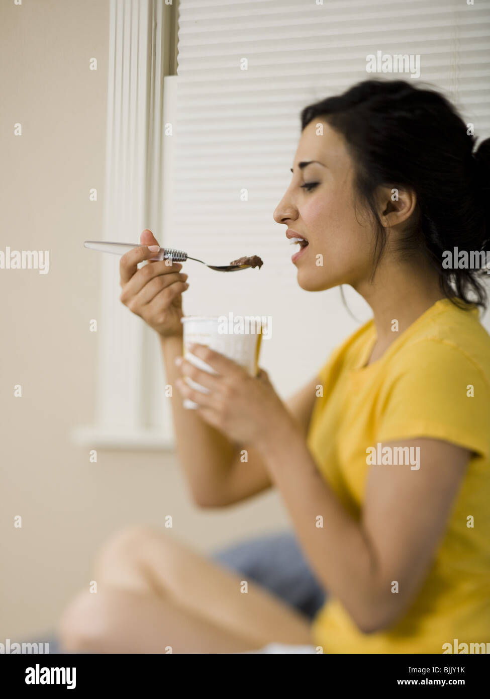 Femme assise et la consommation de crème glacée Banque D'Images
