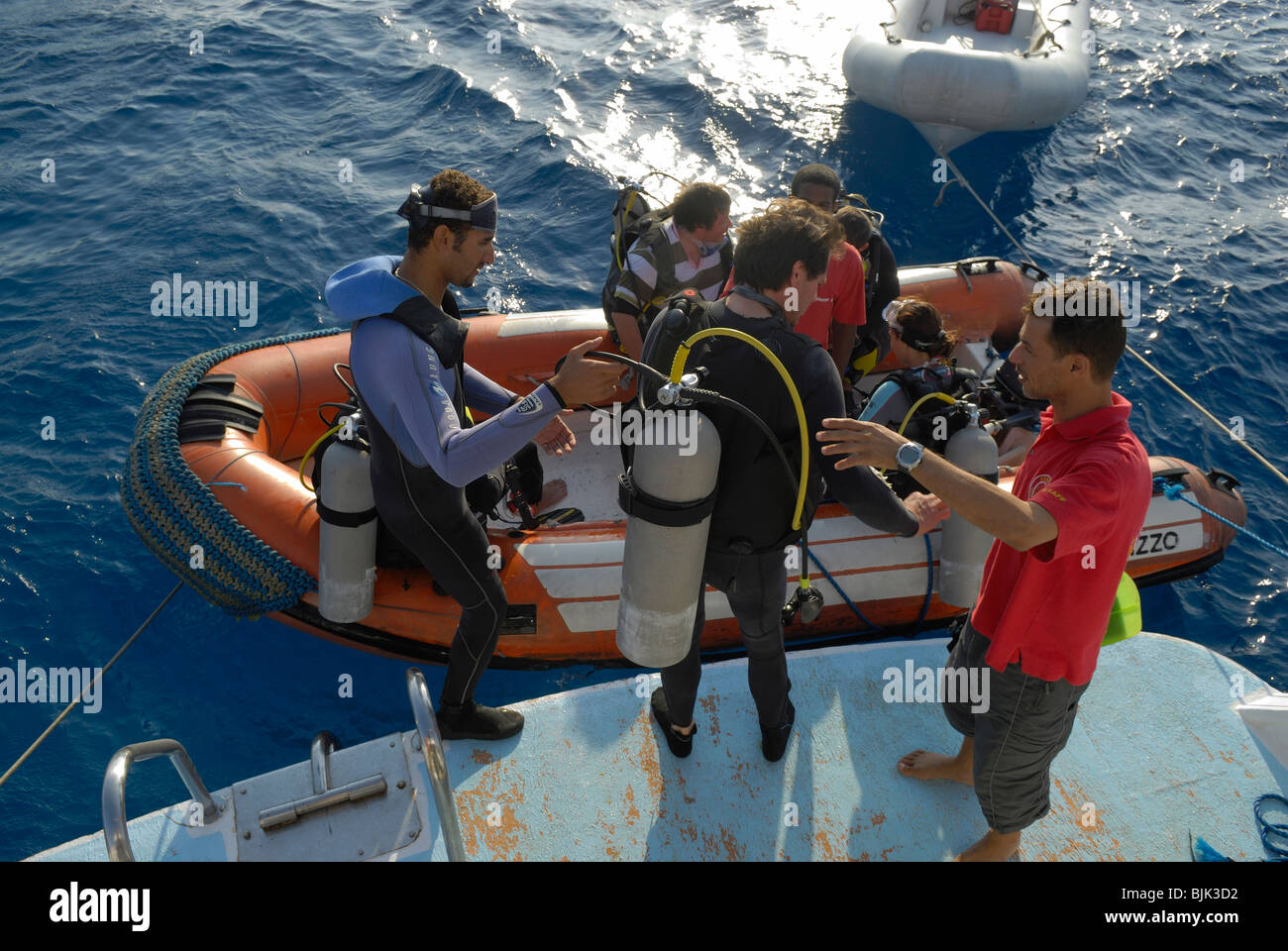 Les plongeurs d'aller dans un bateau gonflable en plongée à Banque D'Images