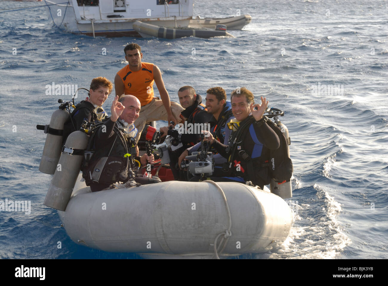 Heureux plongeurs sur un bateau gonflable prêt à plonger Banque D'Images