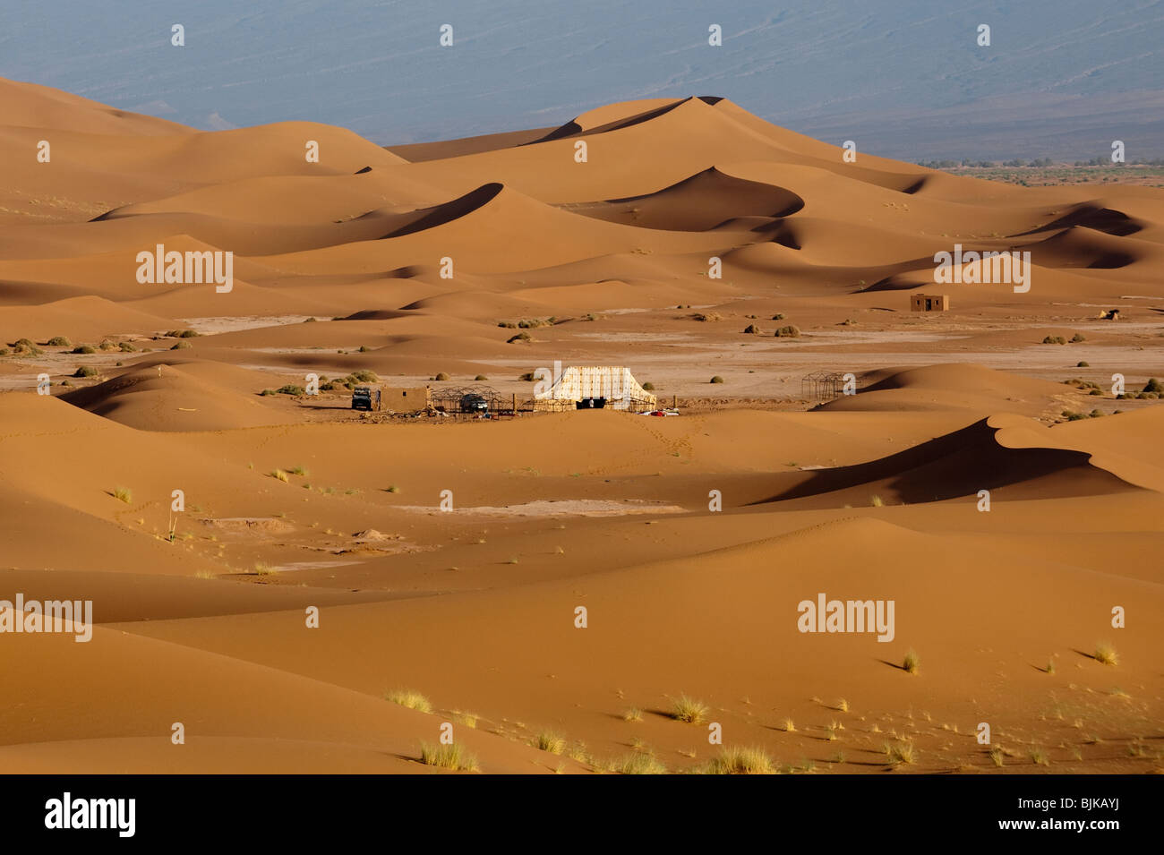 Il s'agit d'une image d'un camp dans le désert au milieu des dunes de sable dans le désert du Sahara Occidental au Maroc. Banque D'Images