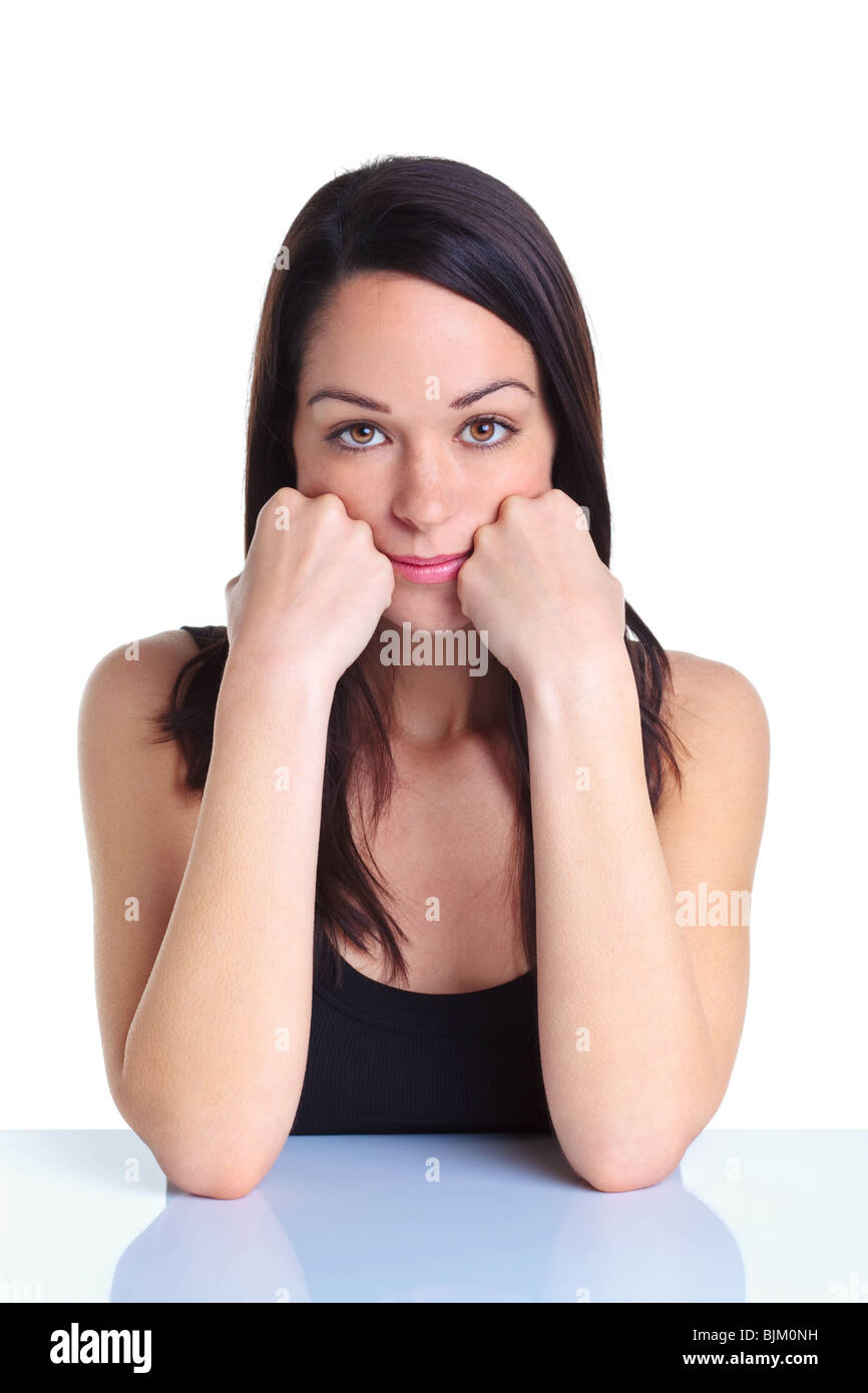 Woman leaning on ses mains à la recherche vers la caméra avec un air sérieux sur son visage, fond blanc. Banque D'Images